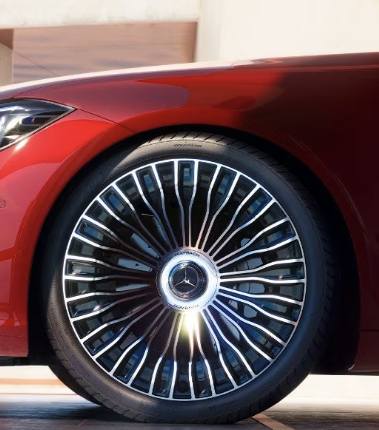 Close-up of Mercedes-Maybach 21-inch forged multi-spoke wheel with intricate silver spokes, chrome center cap with three-pointed star, and low-profile tire