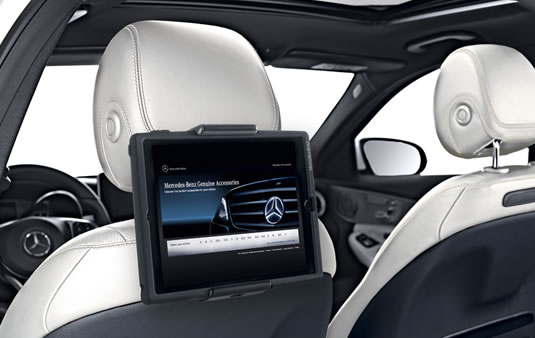 Mercedes-Benz rear seat entertainment system with tablet holder mounted on beige leather headrest, displaying luxury in-car accessories